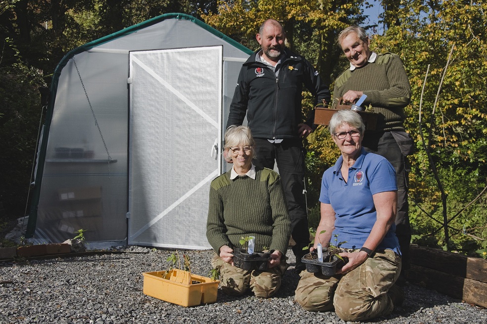 Four members of crew craggy sat outsite of their new poly tunnel